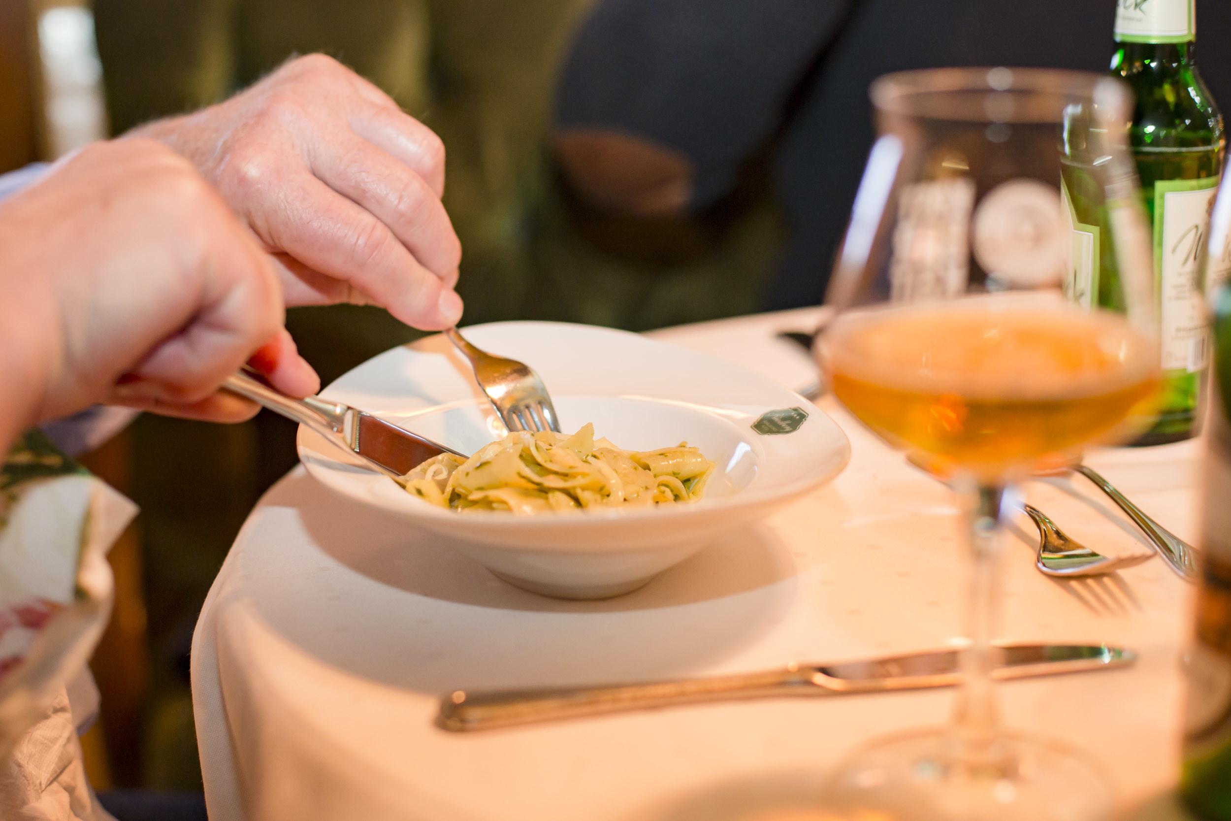 Gäste genießen Biernudeln mit Bärlauchpesto und Parmesan am gedeckten Tisch im Biergasthof Riedberg; Zwischengang des 5-Gang-Weihnachtsmenüs