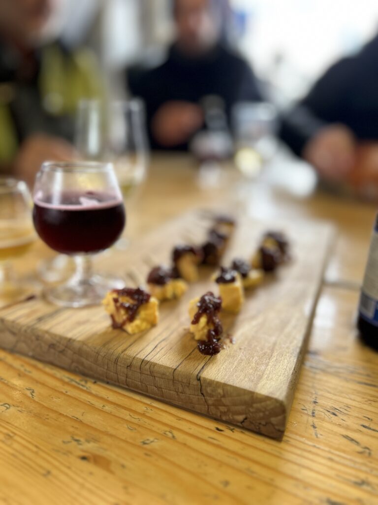 Glas Kirschbier der Mescan Brewery mit regionalem Käse und Zwiebelchutney als Begleitung zur Verkostung.