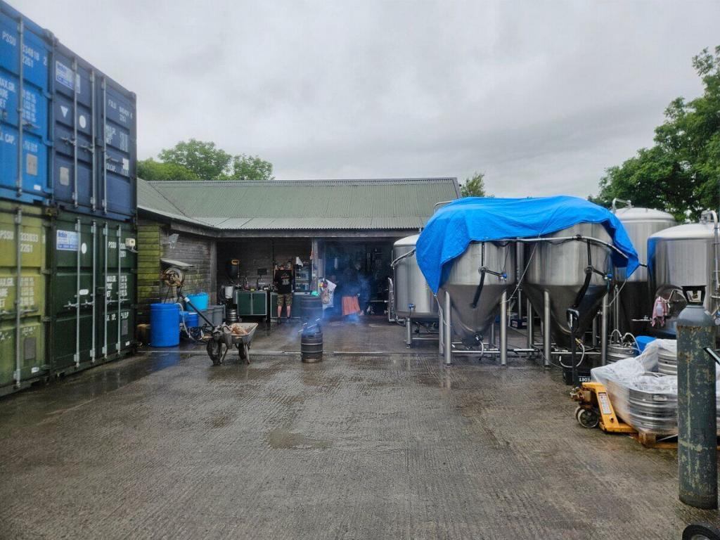Außenansicht der Mescan Brewery mit mehreren Gärtanks im Freien. Die kleine Brauerei liegt mitten in der irischen Landschaft und nutzt jeden verfügbaren Quadratmeter.