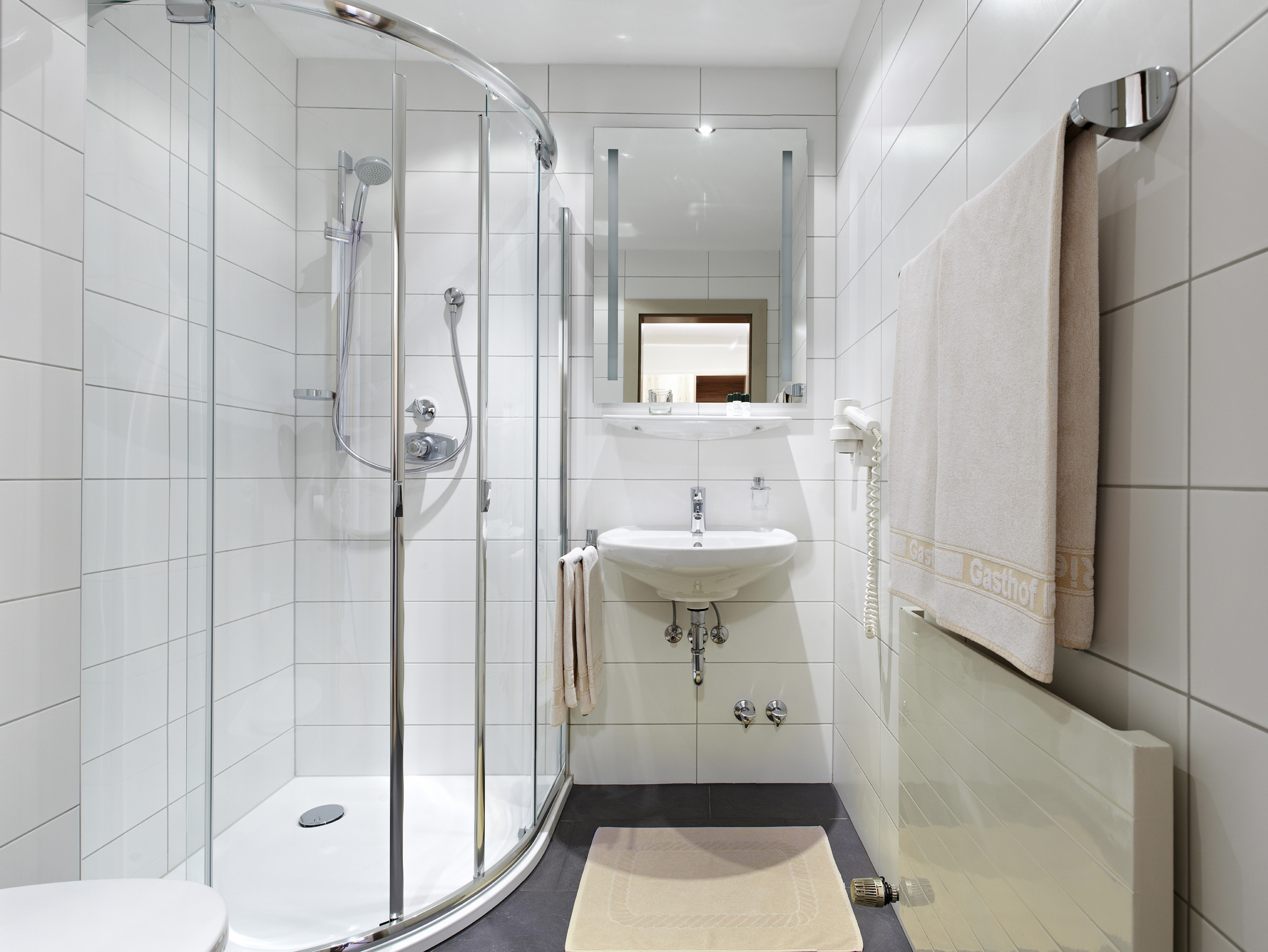 Badezimmer im GENUSS Hotelzimmer des Biergasthof Riedberg mit Dusche, WC und Waschbecken